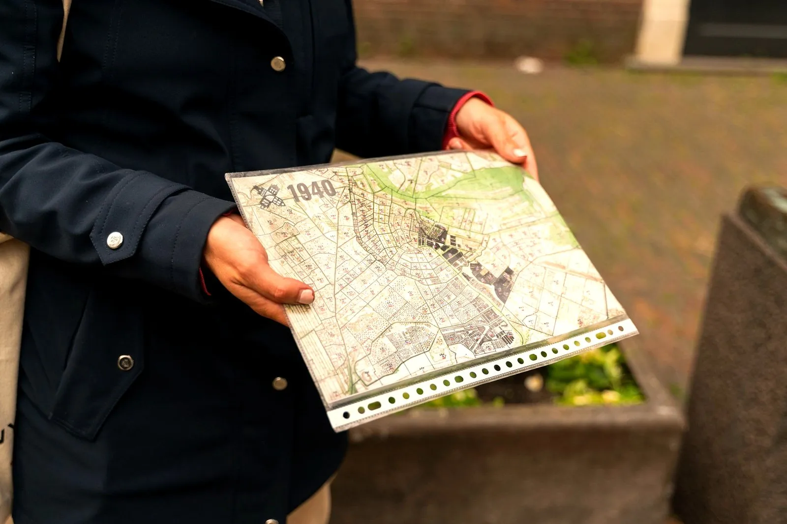 A guide holding a 1940 historical map of Amsterdam during a tour
