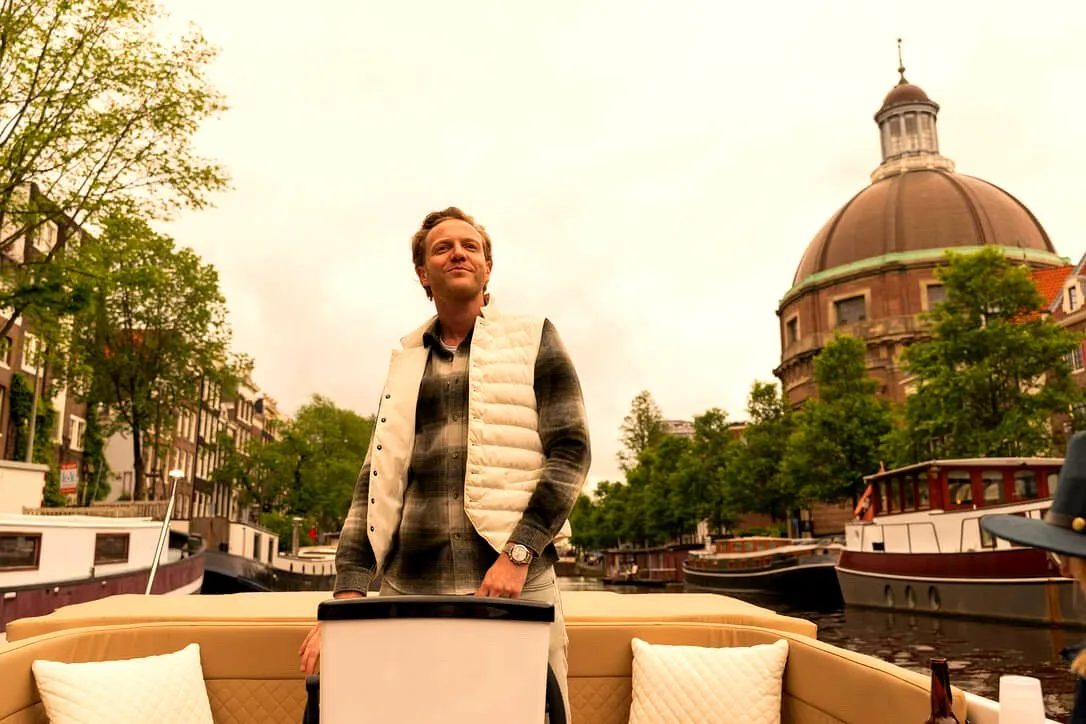 A guest standing on a private boat with the Lutherse Kerk dome behind