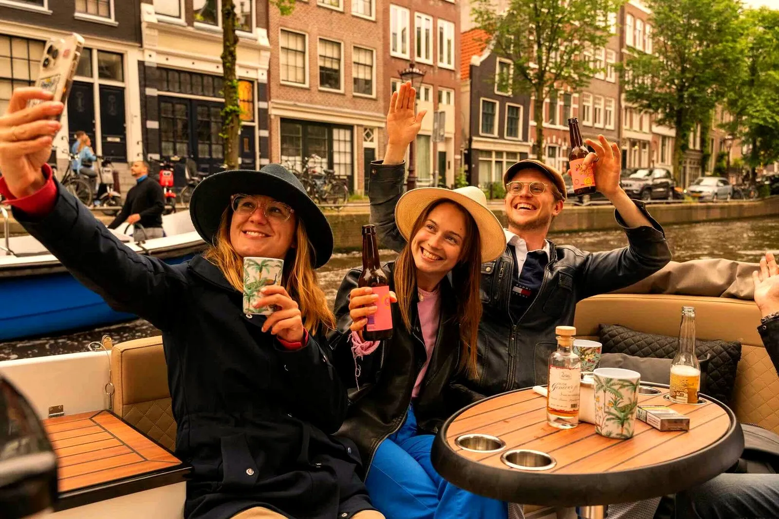 Guests taking a selfie with drinks on a private Amsterdam canal boat