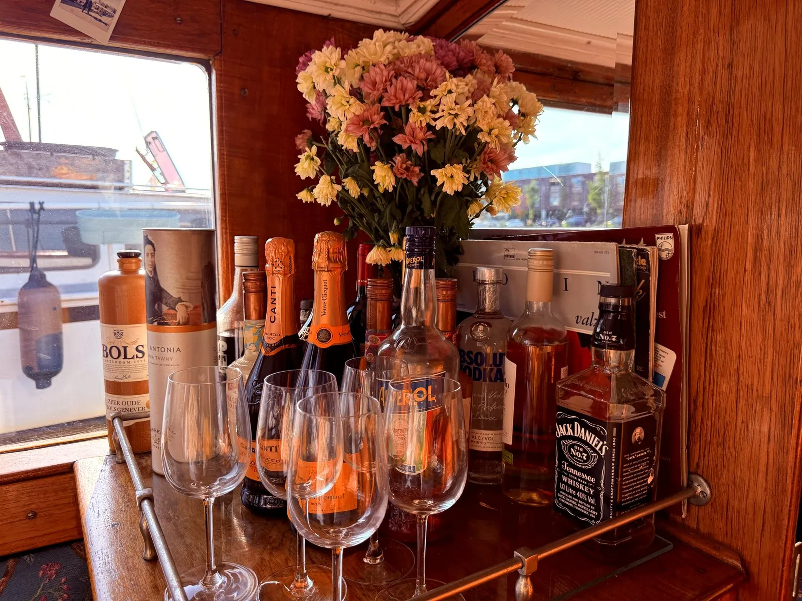 The drinks bar on an Amsterdam salon boat with bottles, glasses and fresh flowers