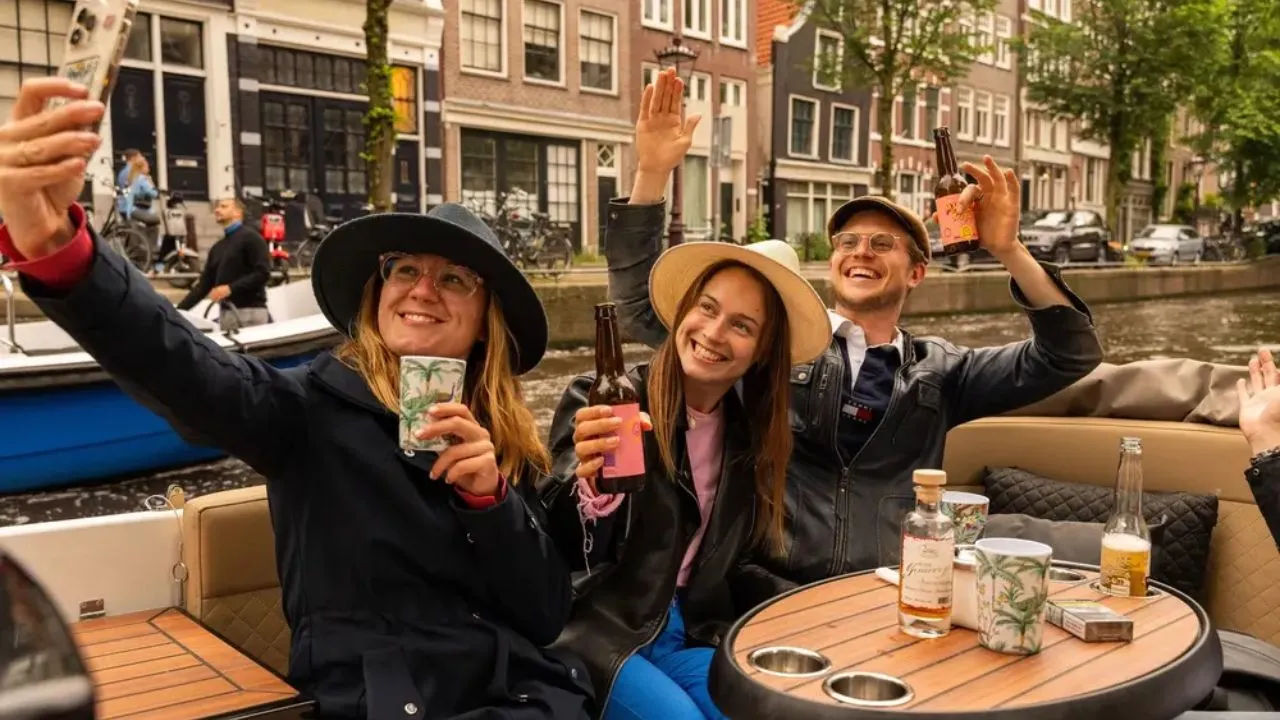 People enjoying a private boat tour in Amsterdam while taking a selfie together on the canal