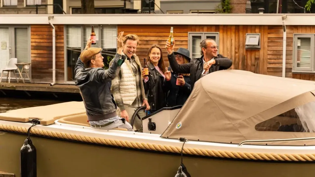 People on a private boat tour in Amsterdam enjoying drinks in hand while relaxing on the canal