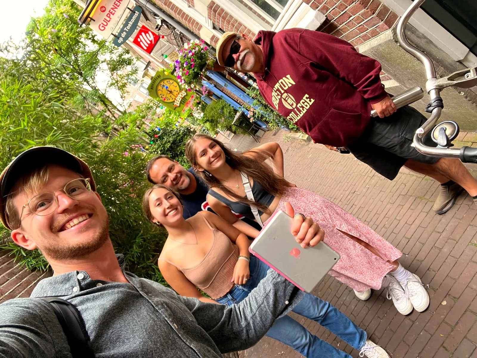 A family and their guide squeeze into a selfie on a brick street in Amsterdam
