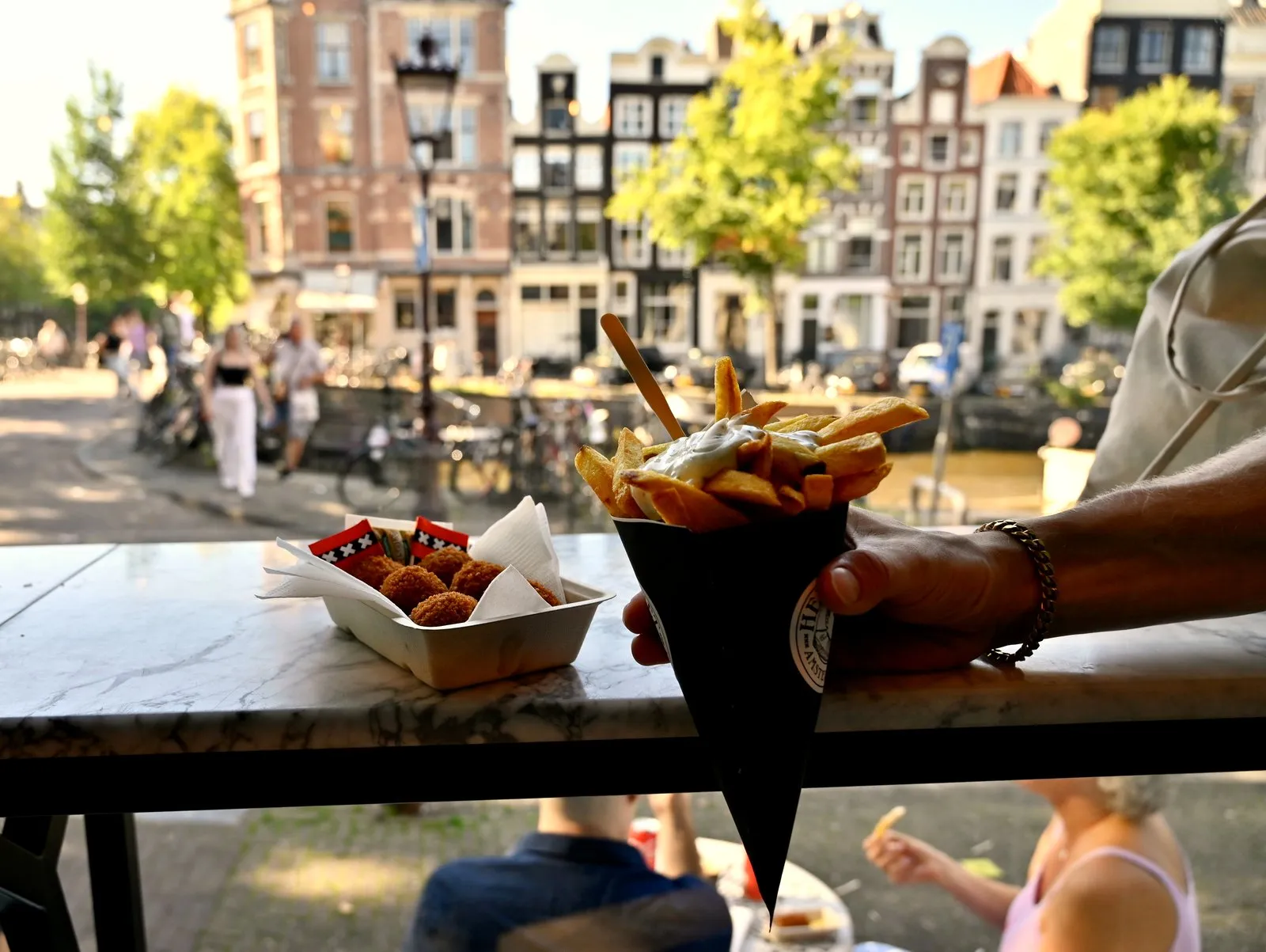Fries and bitterballen with Amsterdam canal houses in the background