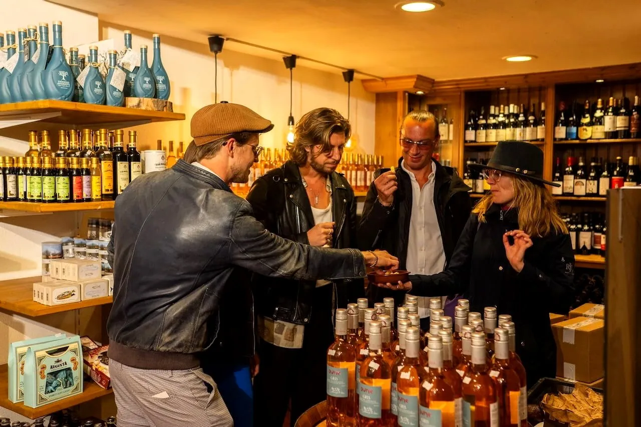 A guide and guests tasting local liqueurs between shelves of bottles in an Amsterdam shop