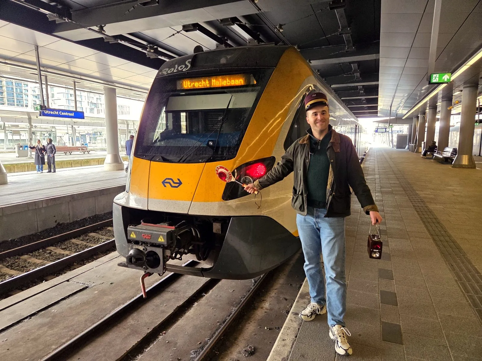 Man beside a yellow Dutch NS train at Utrecht Centraal platform