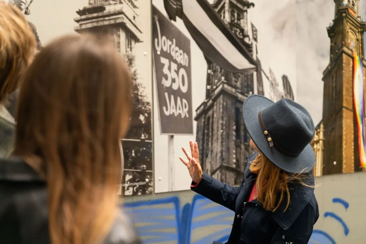 A guide pointing out a historic photo display to guests on an Amsterdam walking tour