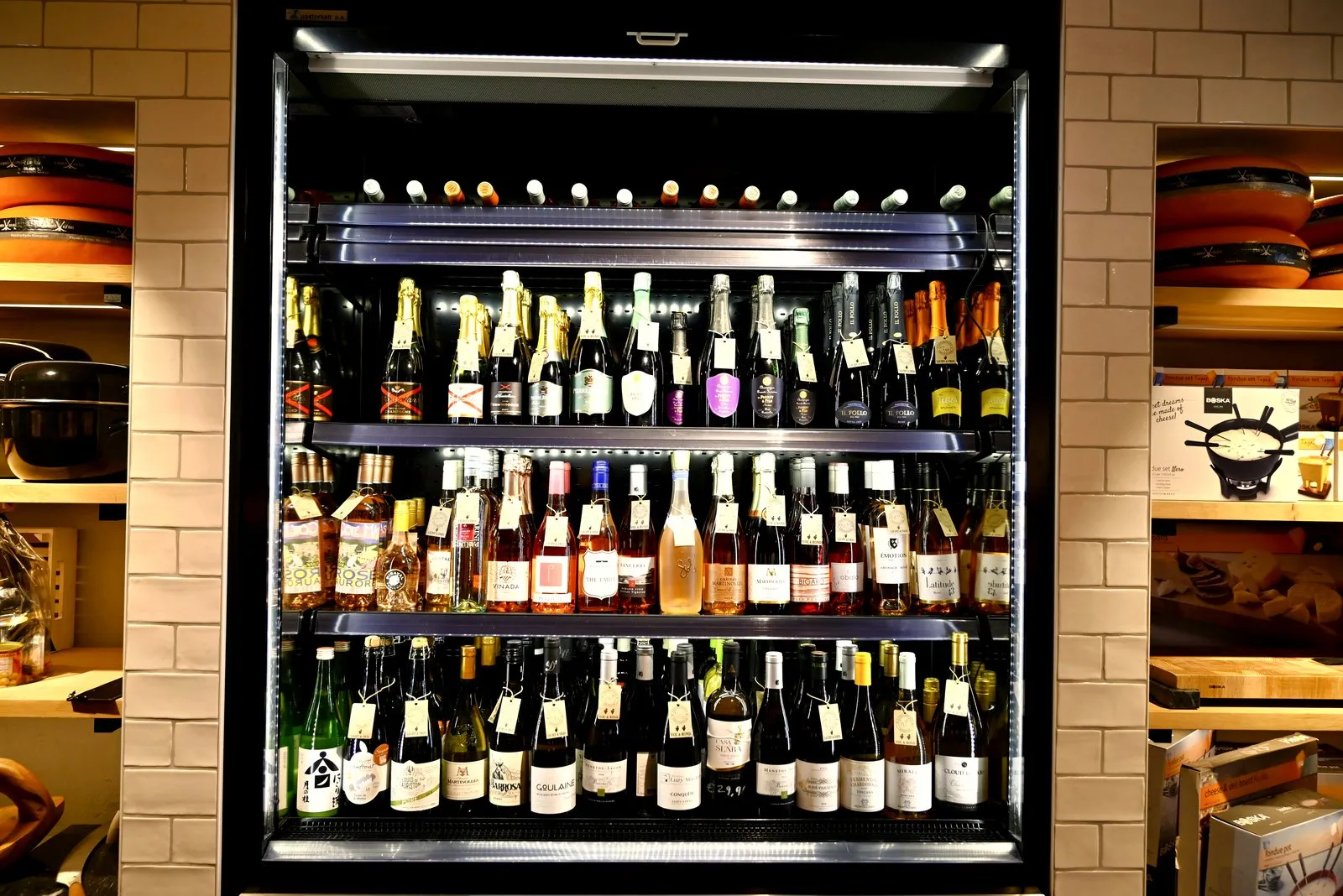 A glass fridge full of wine and sparkling bottles in an Amsterdam tasting shop
