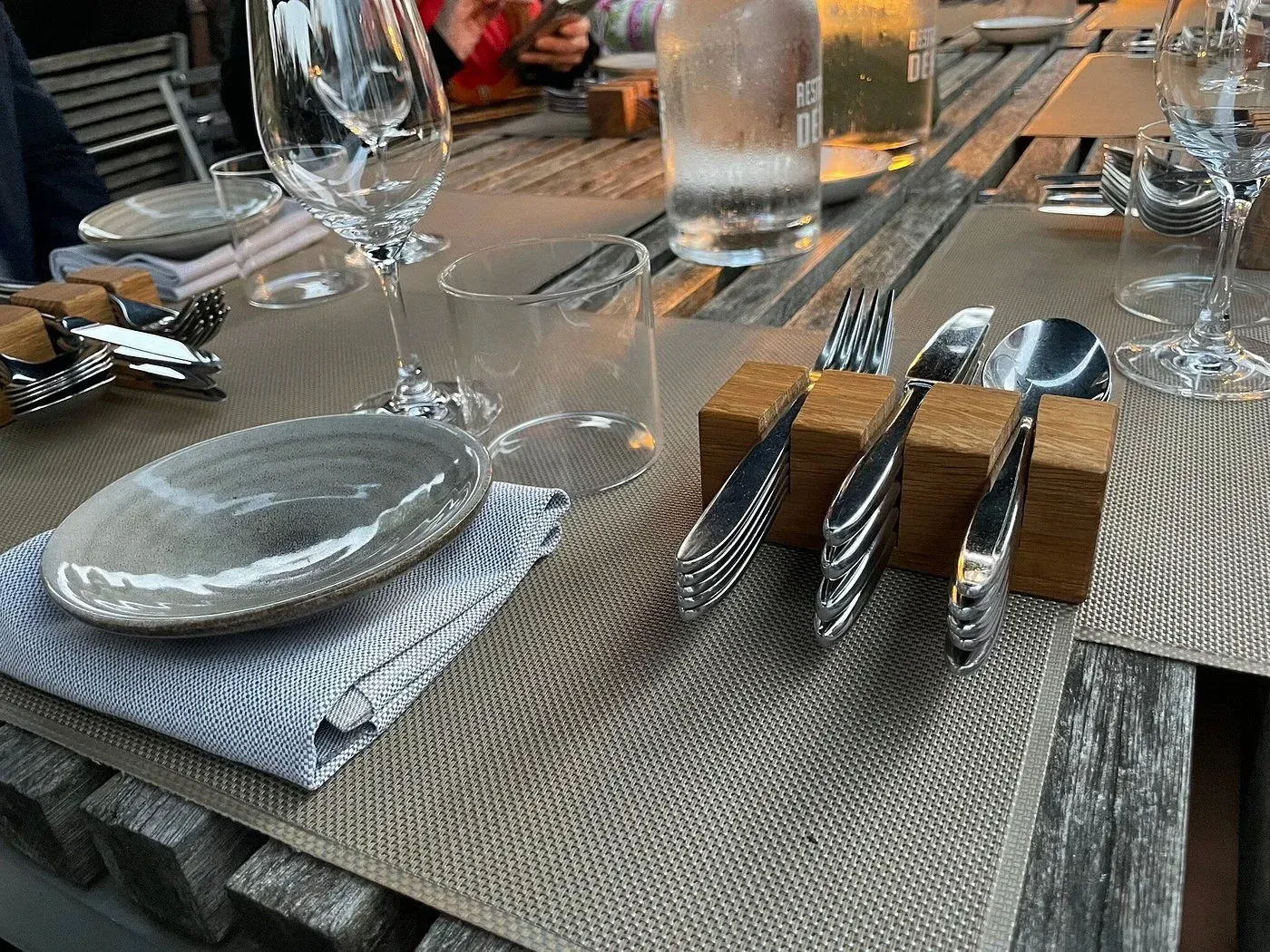 Set table at De Kas with cutlery, wine glasses and a wooden napkin holder