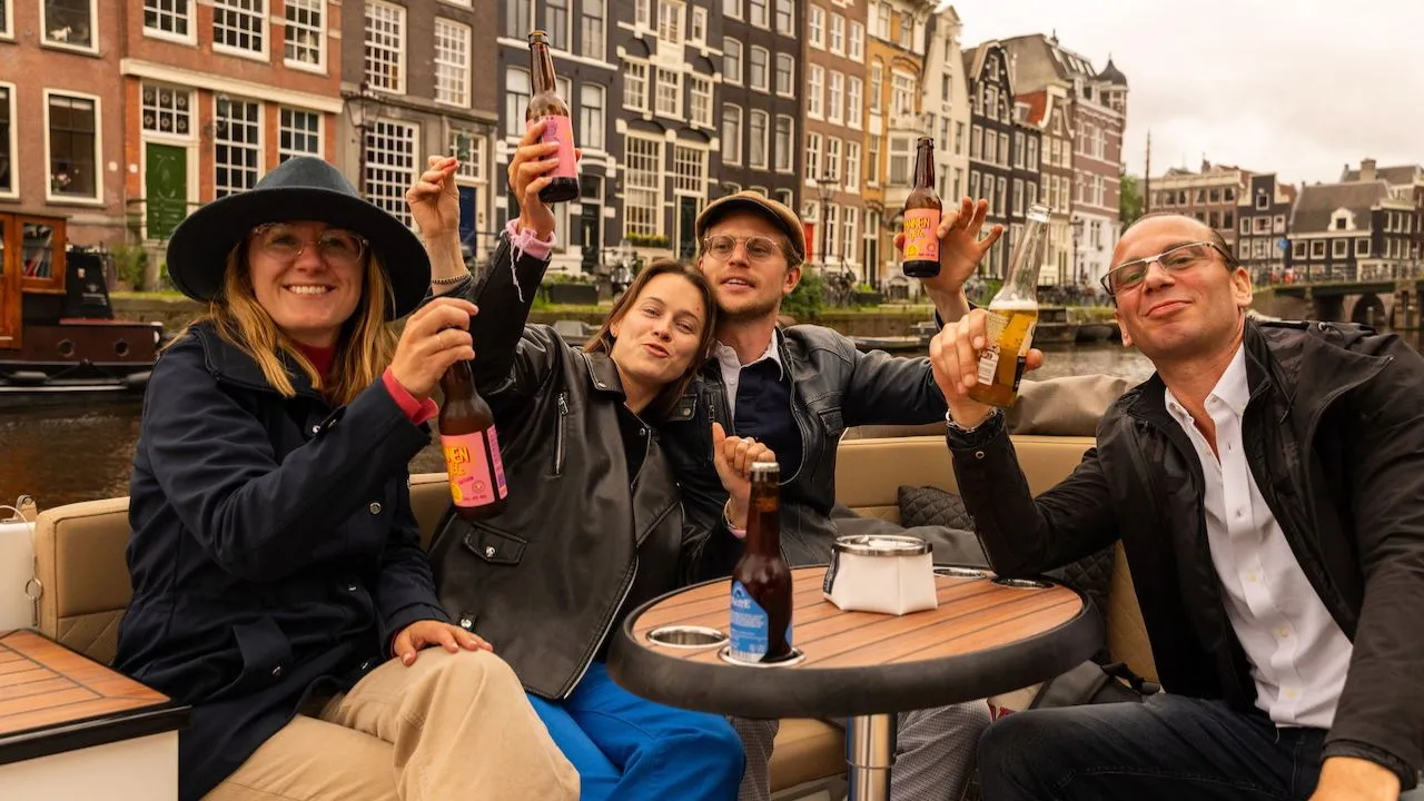 People enjoying a relaxed canal cruise in Amsterdam, sharing laughs and taking in the historic waterfront views.