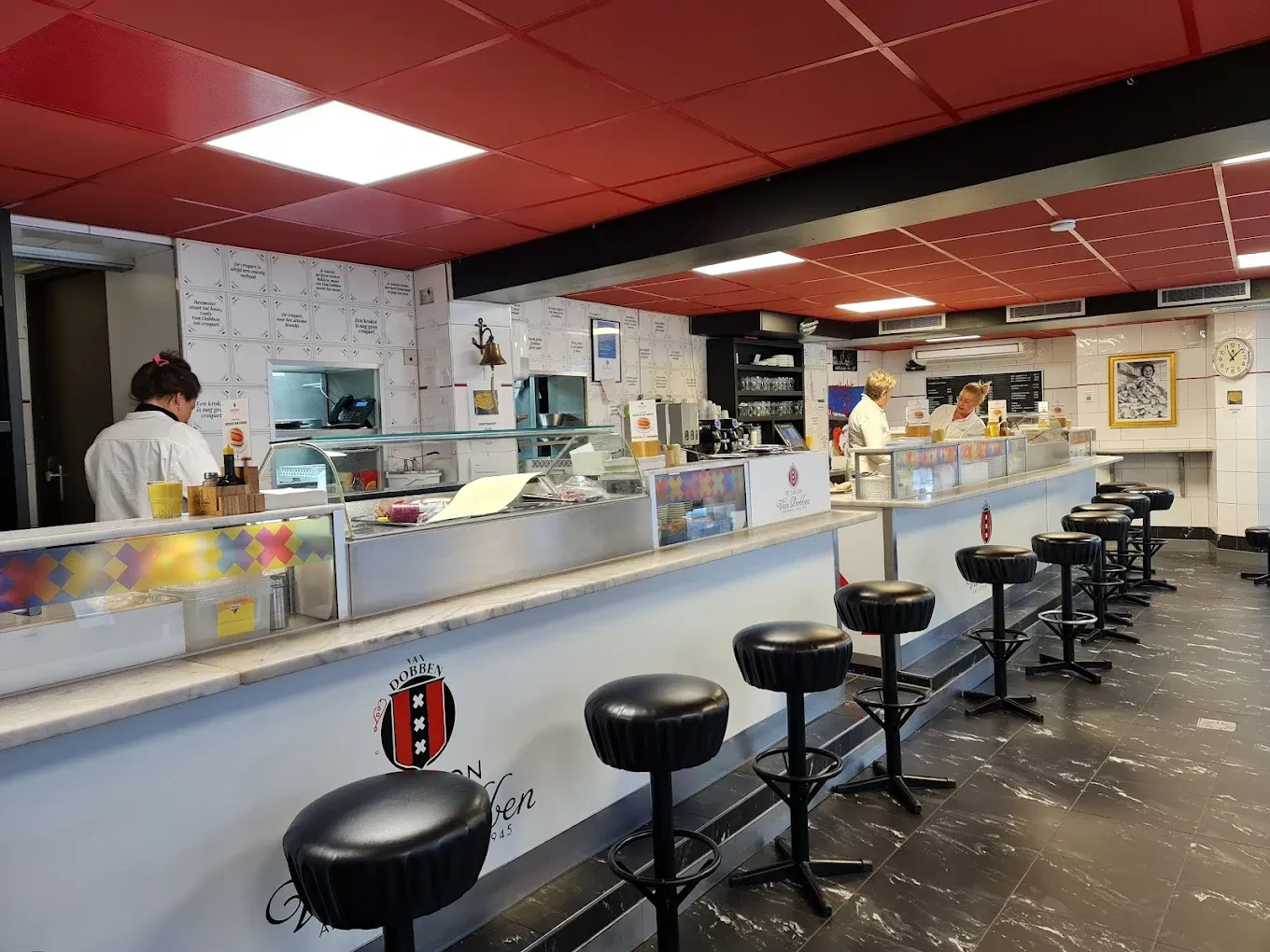 Inside Eetcafe van Dobben in Amsterdam, a classic lunchroom counter with red bar stools